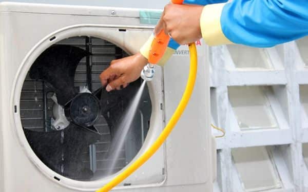 Vệ sinh cục nóng điều hòa để loại bỏ bụi bẩn và lá cây